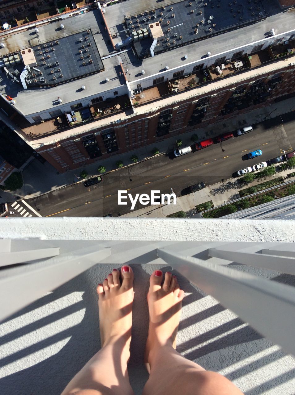 Low section of woman standing by railing in balcony