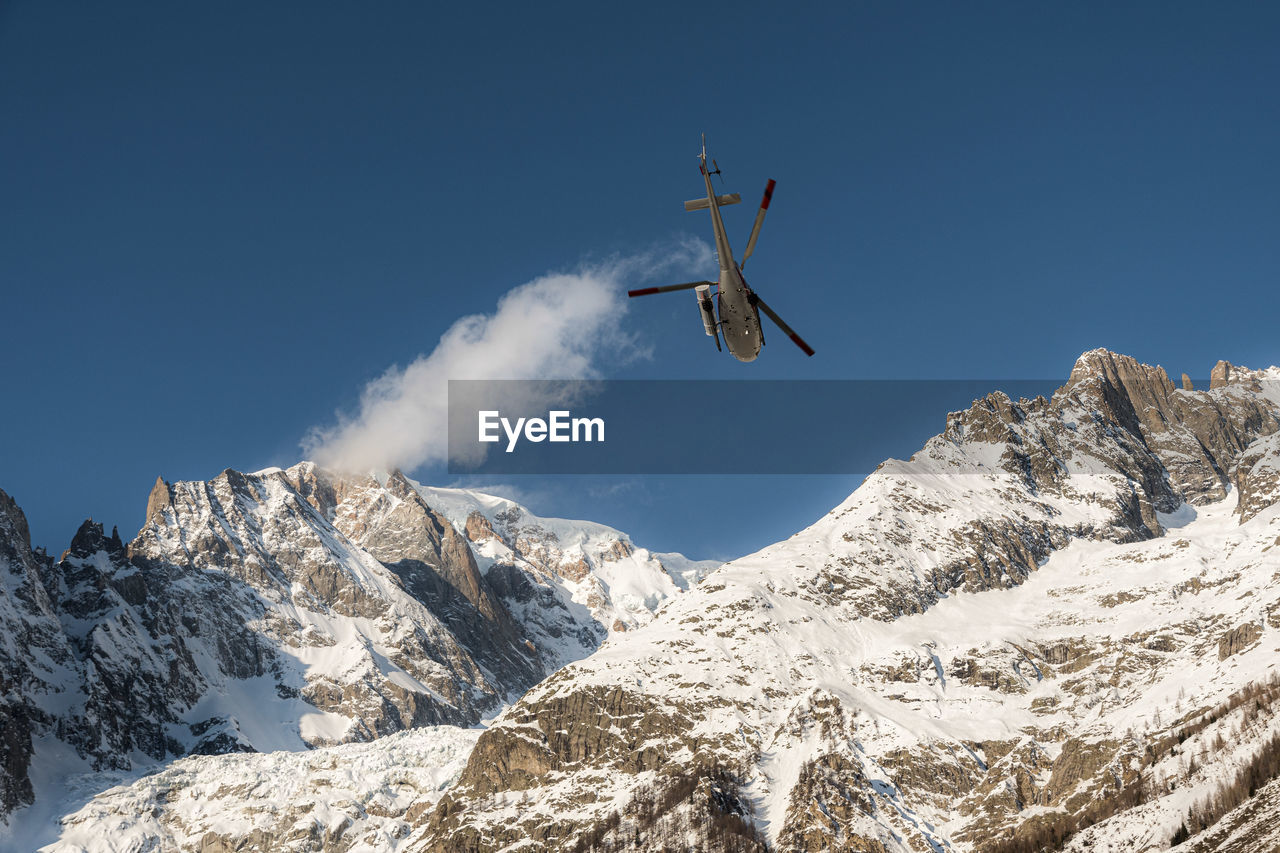 LOW ANGLE VIEW OF SNOWCAPPED MOUNTAIN AGAINST CLEAR SKY