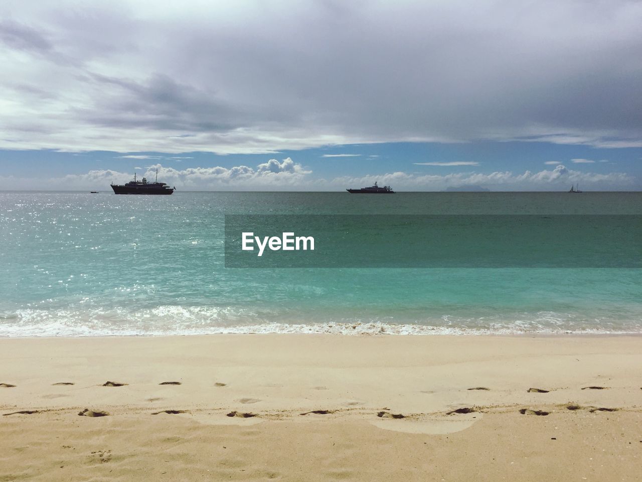 Scenic view of calm sea against cloudy sky