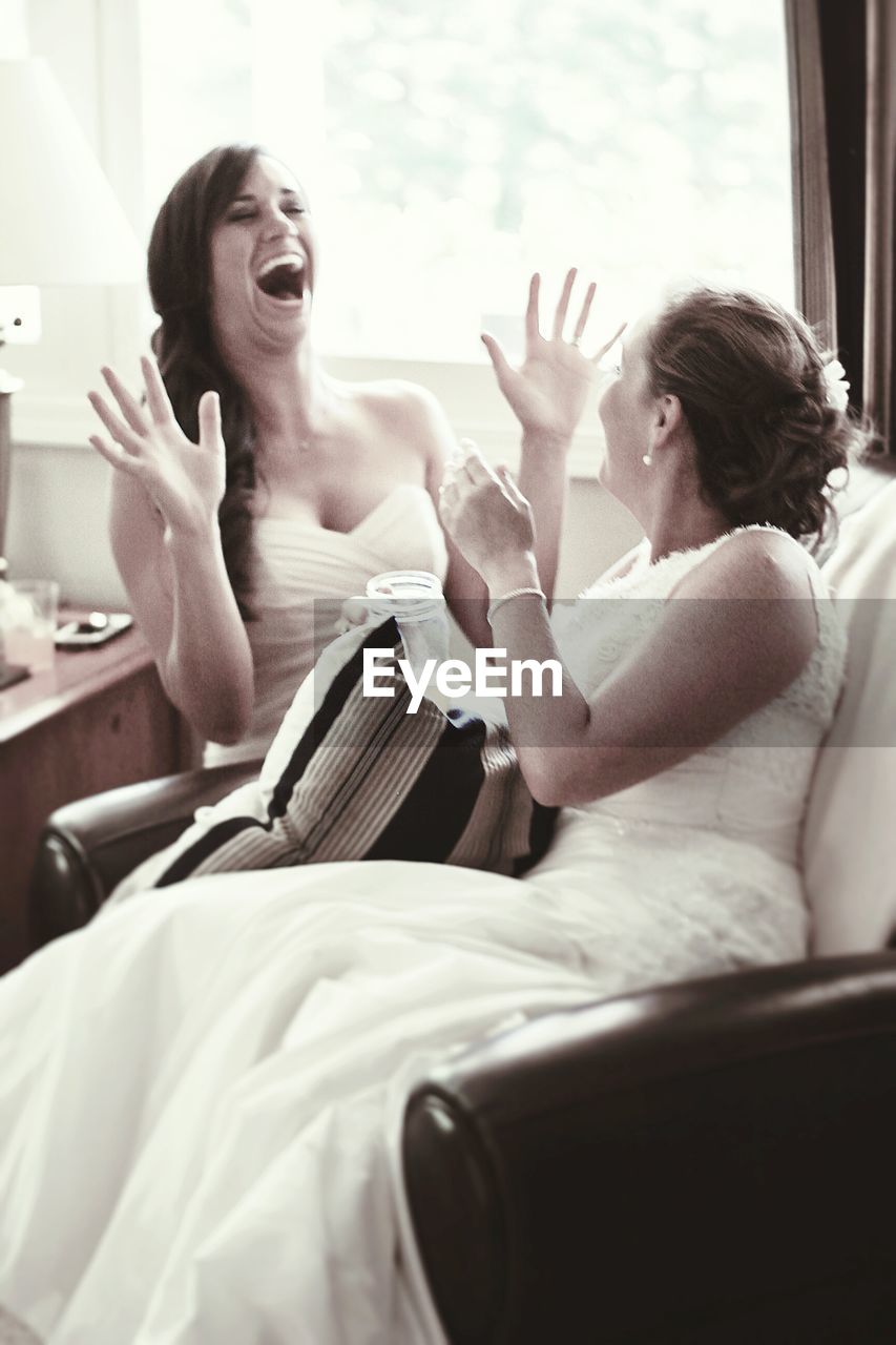Bride laughing with friend at home