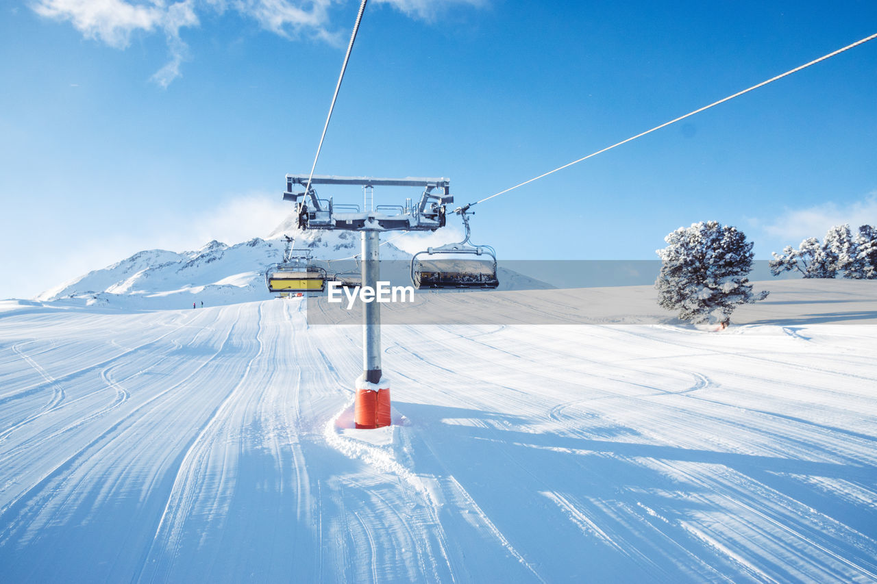 Ski lift over snowcapped mountain against sky