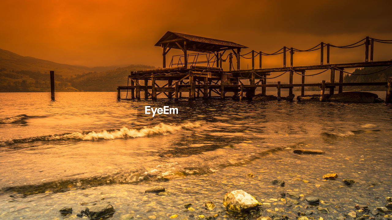 PIER ON BEACH DURING SUNSET