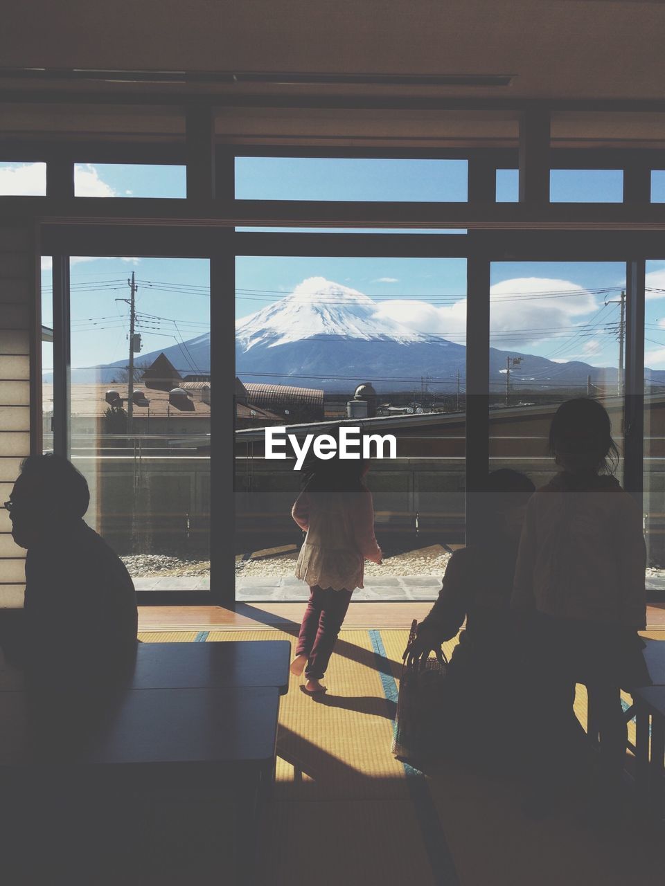 People in building by window against mt fuji