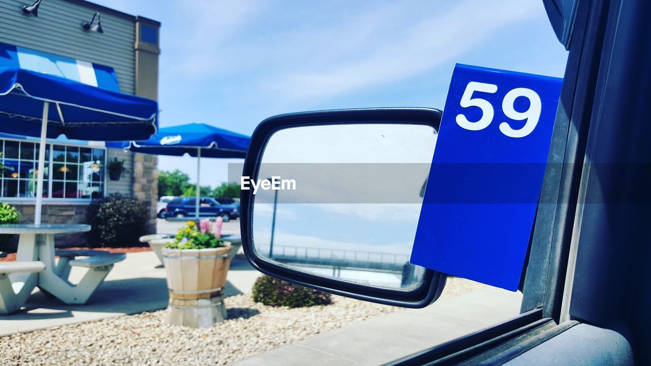 CLOSE-UP OF ROAD SIGN AGAINST BLUE SKY