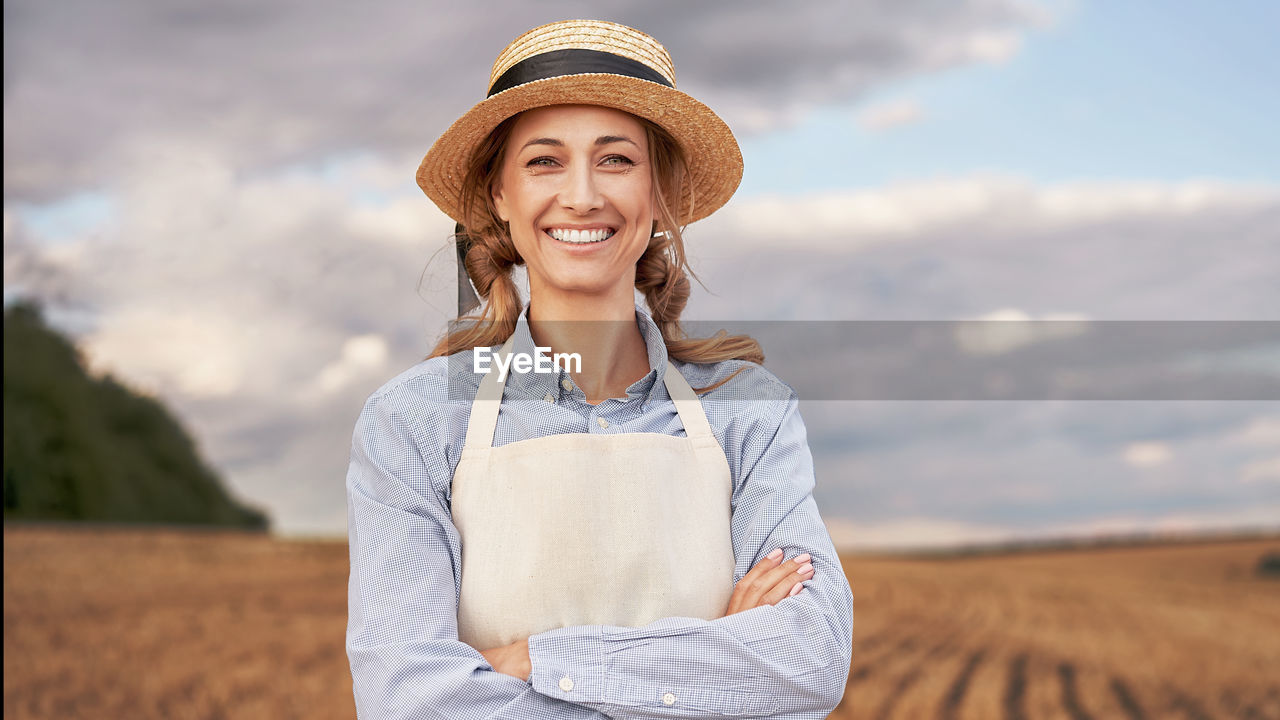 PORTRAIT OF SMILING YOUNG MAN STANDING ON FIELD