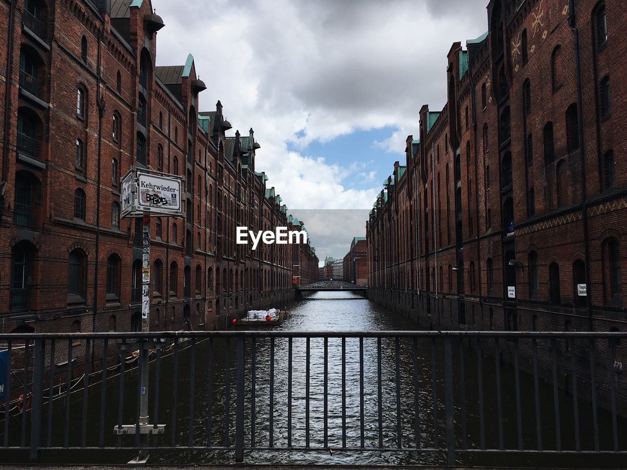 Canal amidst buildings against sky in city