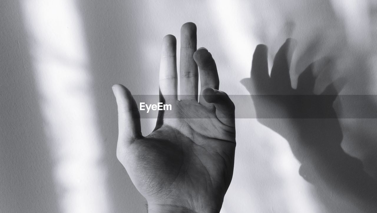 Close-up of hand against wall