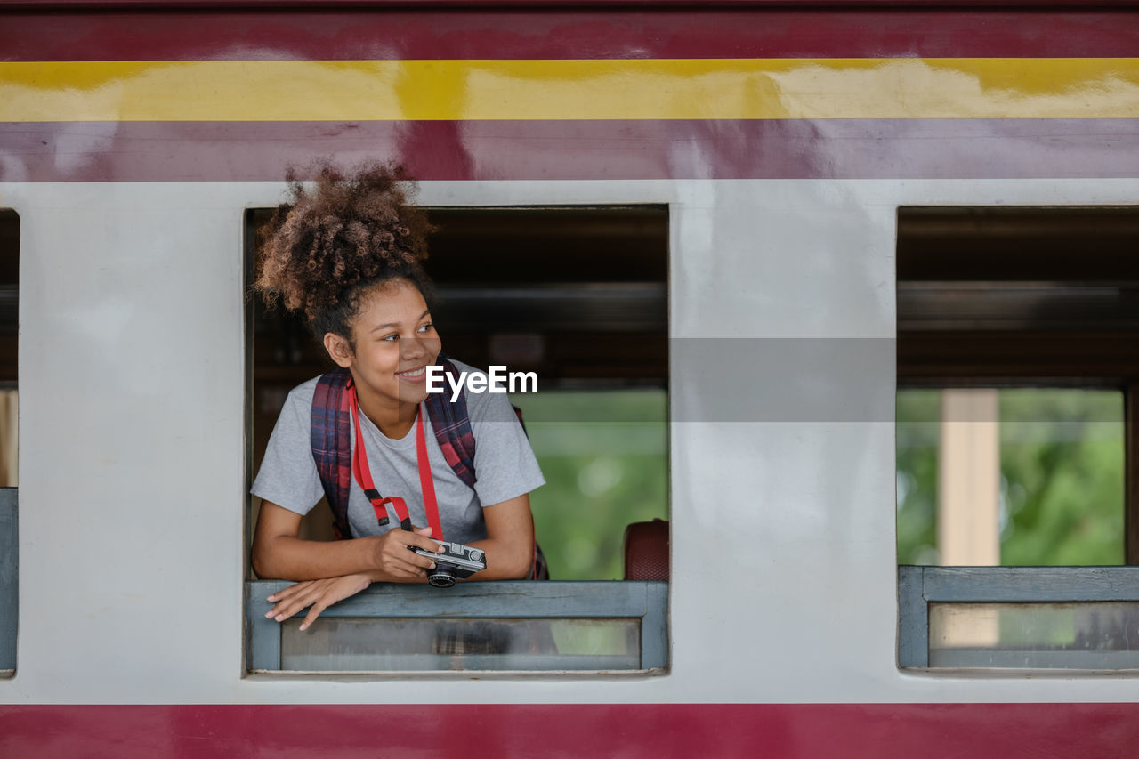 portrait of smiling young woman using mobile phone