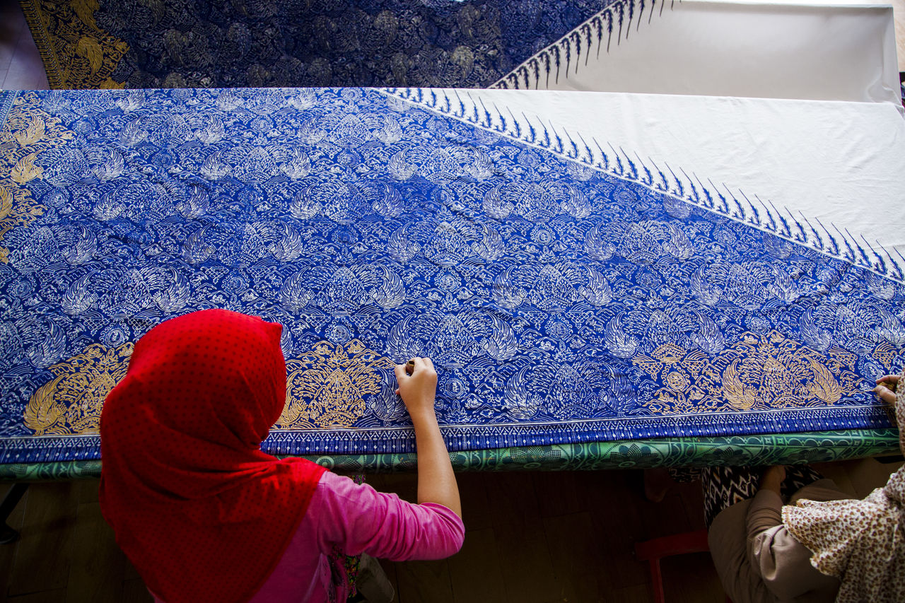 High angle view of woman making artwork on fabric