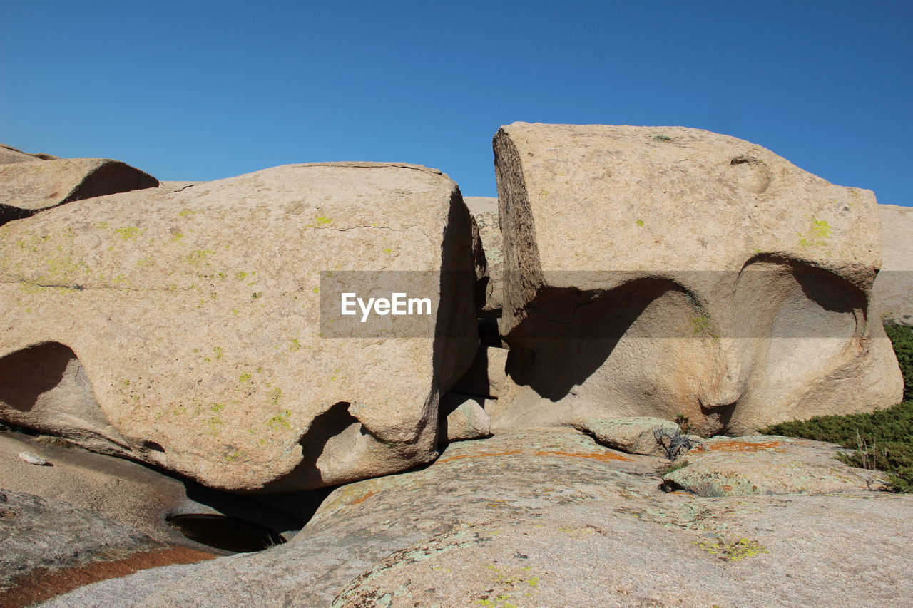 A huge round volcanic white stone split in half on the rocks in the bektau-ata tract, summer