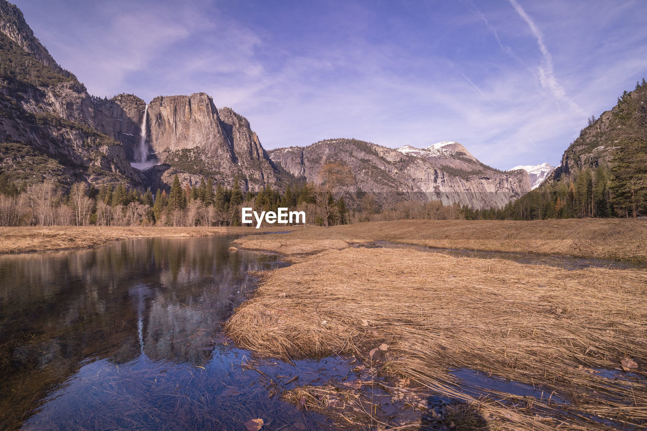 Scenic view of lake by mountains against sky