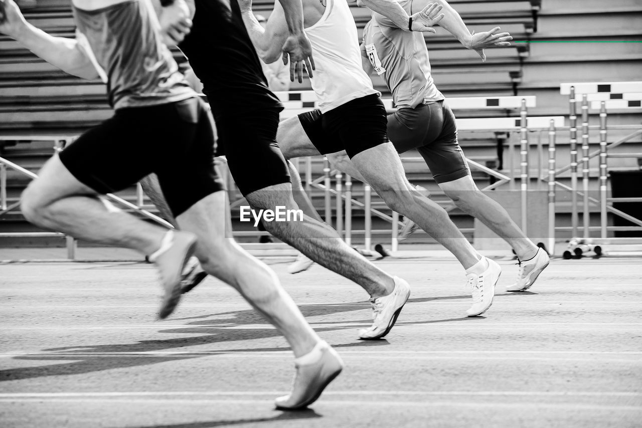 Run sprint race male athletes at stadium black and white photo