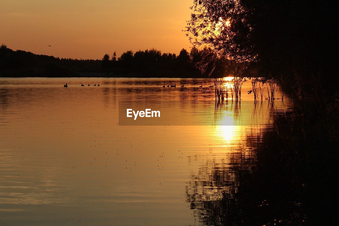 SCENIC VIEW OF LAKE AT SUNSET