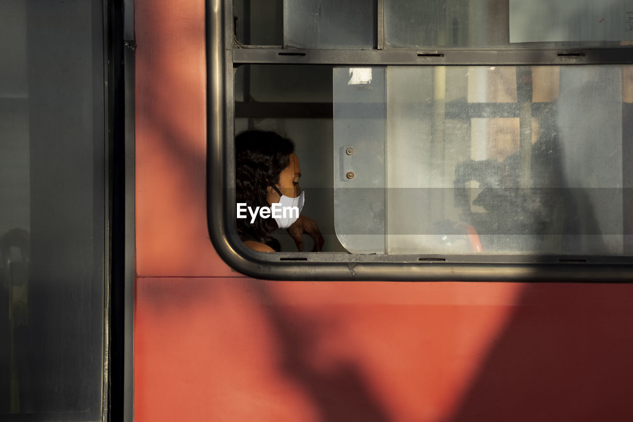 REFLECTION OF WOMAN ON TRAIN WINDOW