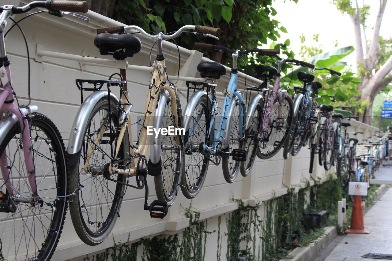 Bicycles parked on retaining wall in city