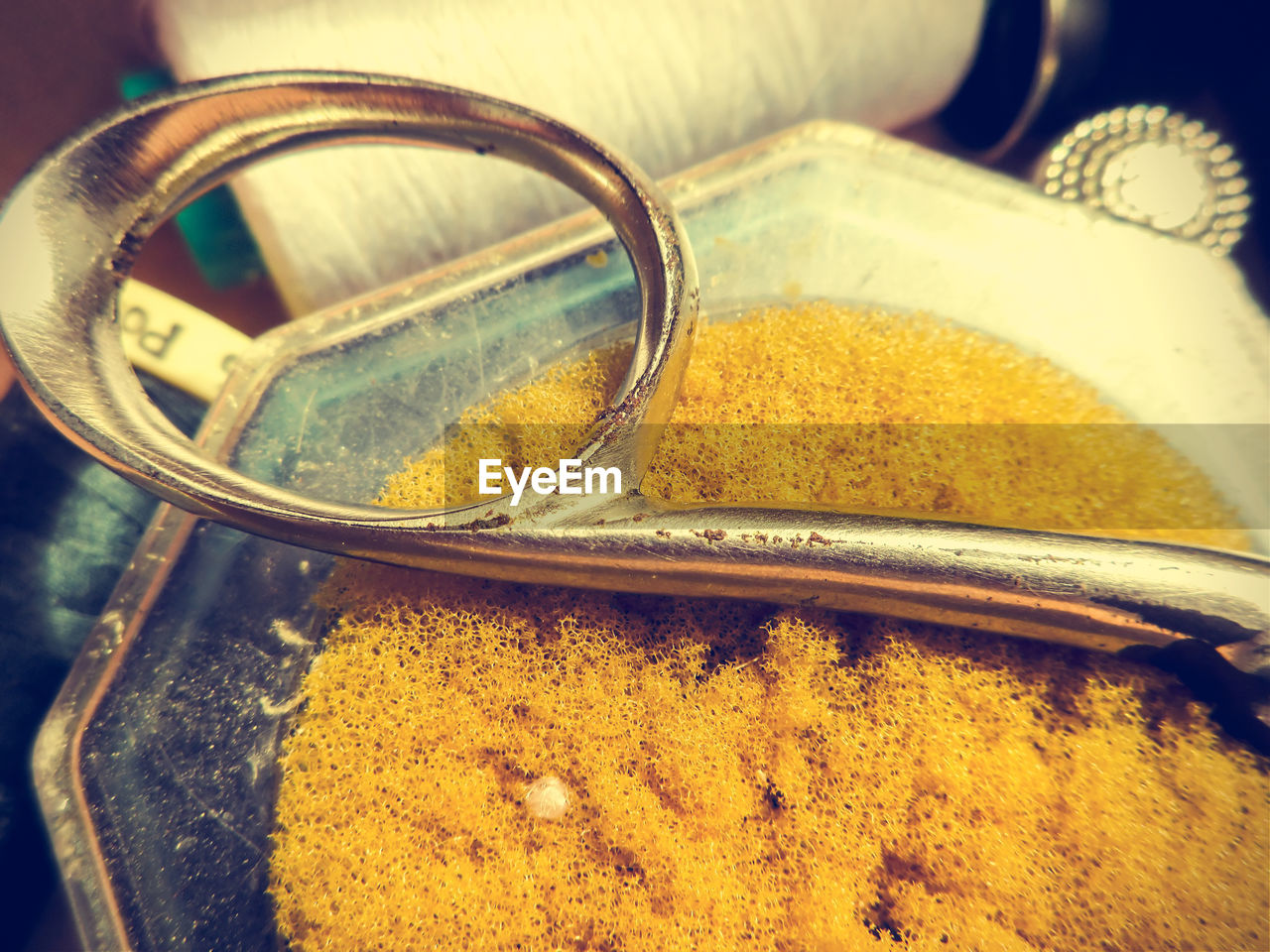 HIGH ANGLE VIEW OF YELLOW CONTAINER ON METAL TABLE