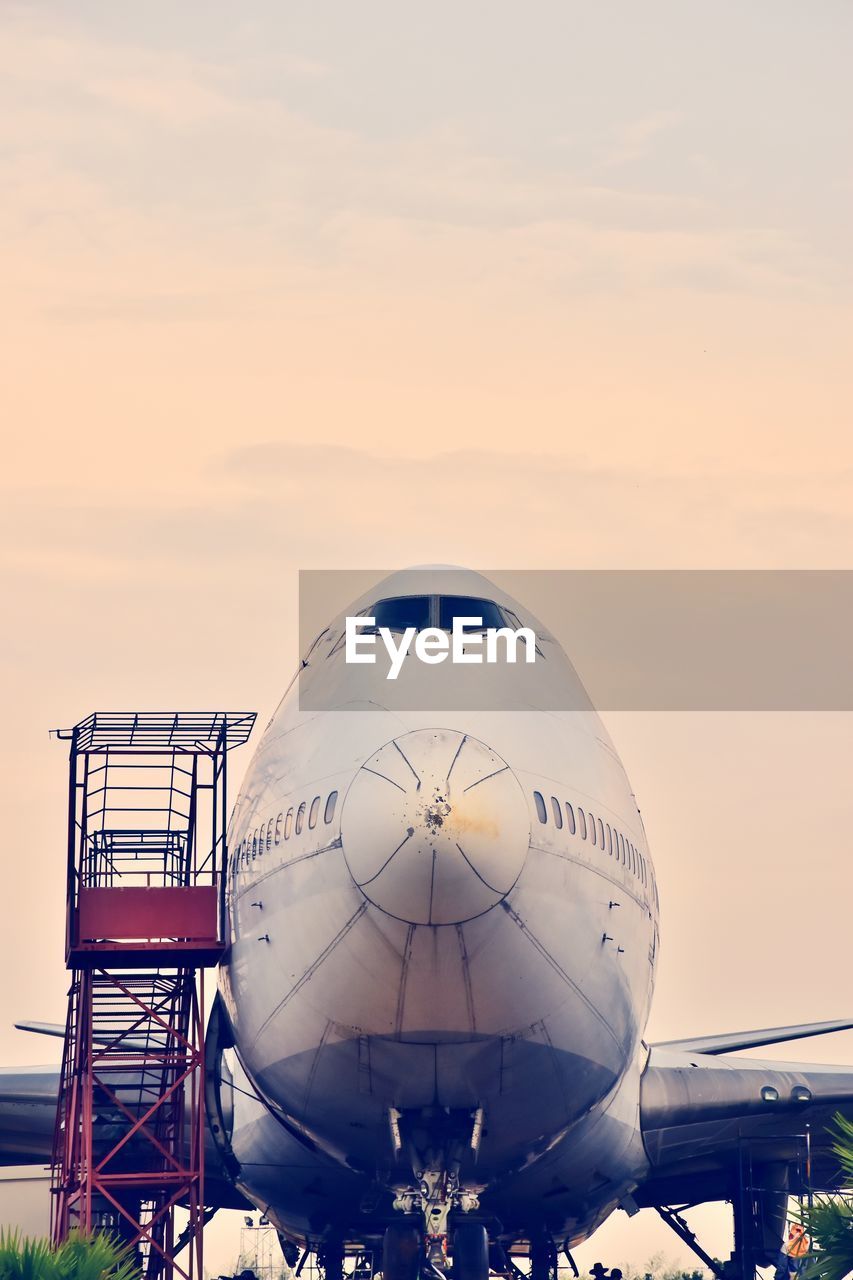 AIRPLANE ON RUNWAY AGAINST SKY DURING SUNSET