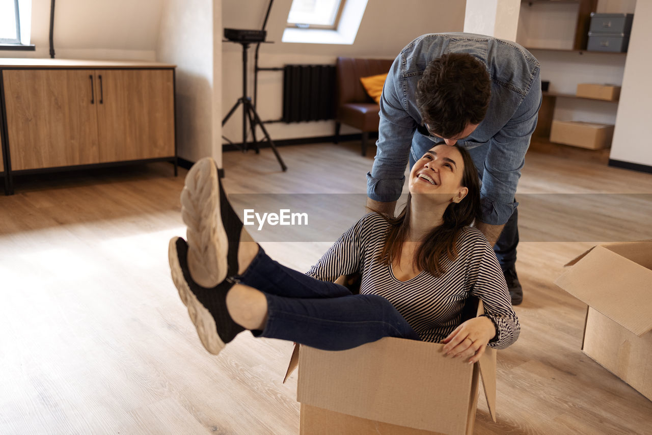 rear view of woman sitting on floor at home