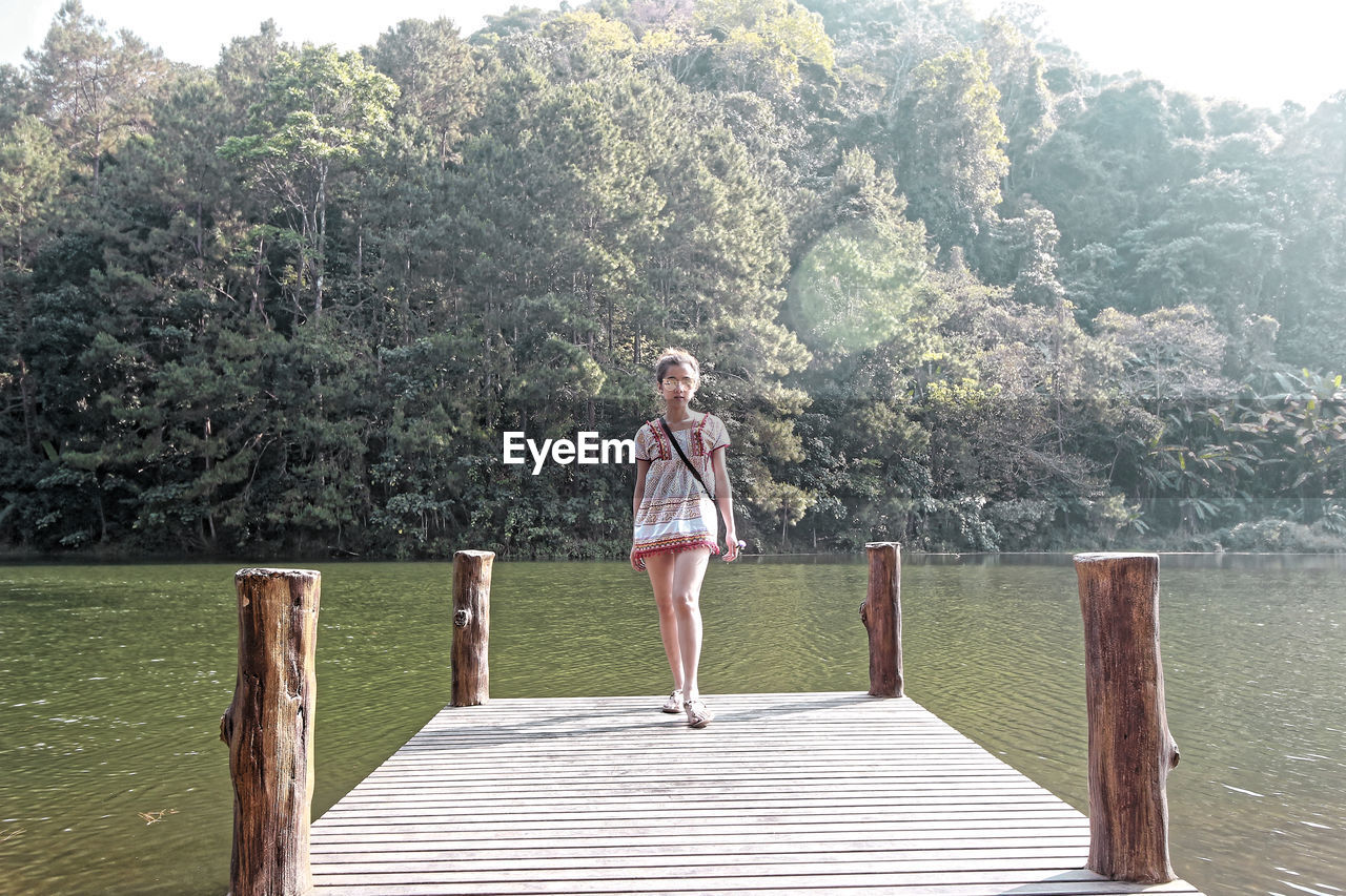 Full length of girl standing on pier over lake