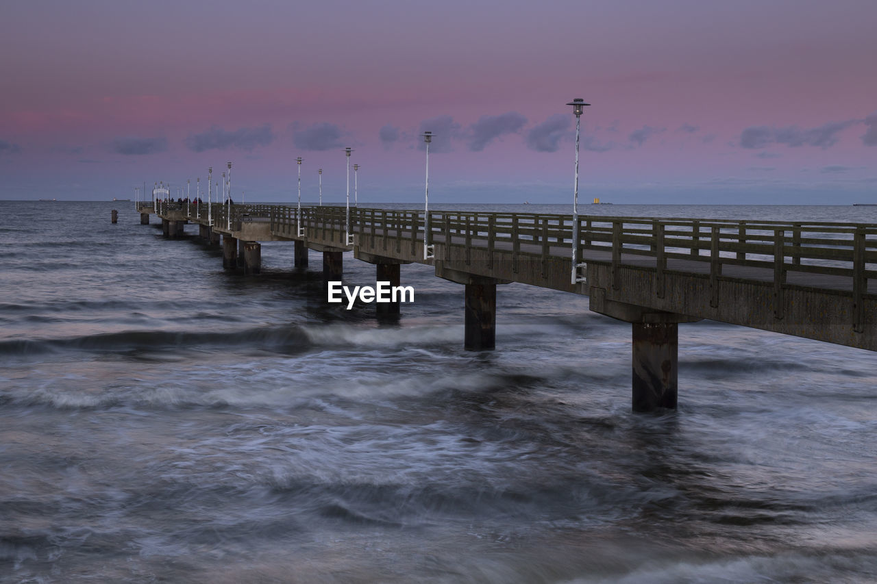 View of long bridge at calm sea