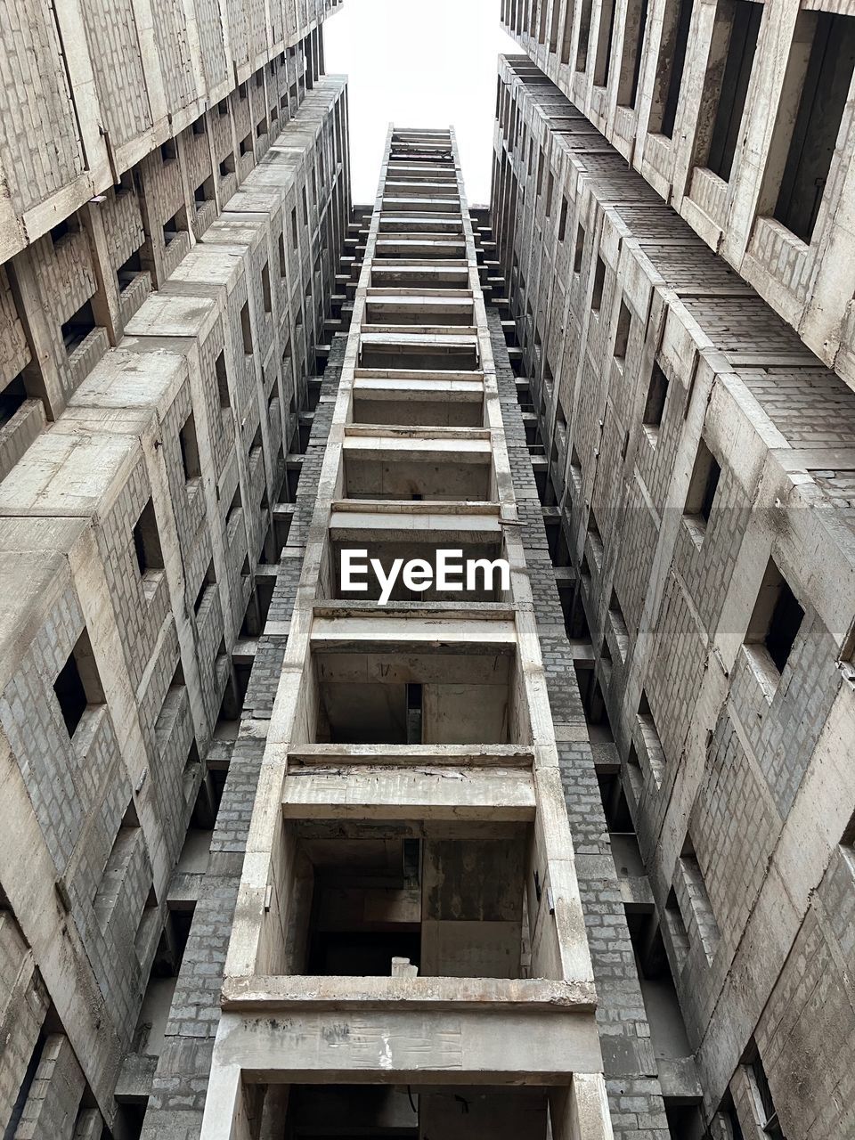 architecture, built structure, building exterior, building, low angle view, no people, city, skyscraper, staircase, urban area, day, outdoors, black and white, facade, monochrome, pattern, steps and staircases, tower block