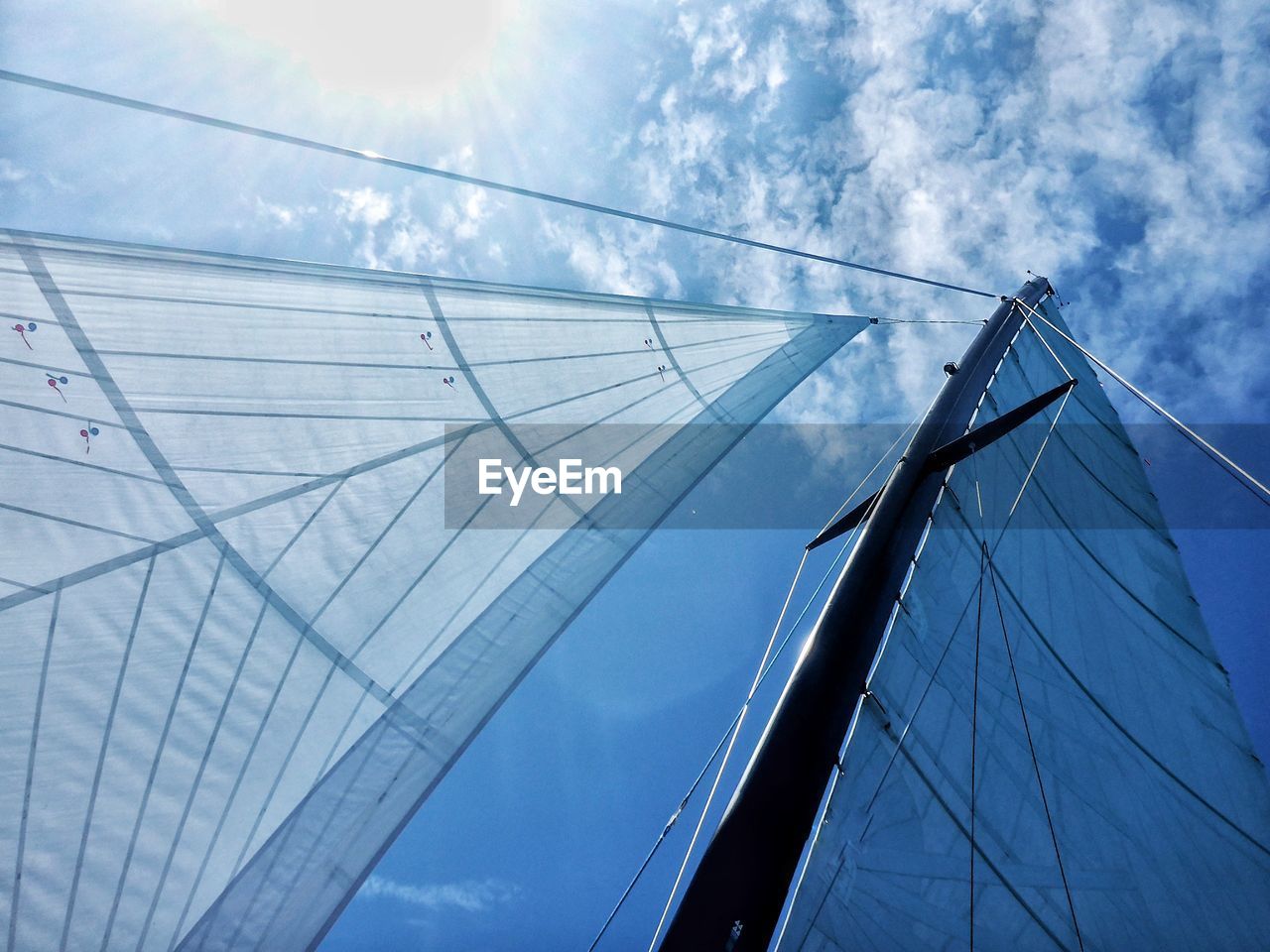 Low angle view of mast and sail against sky