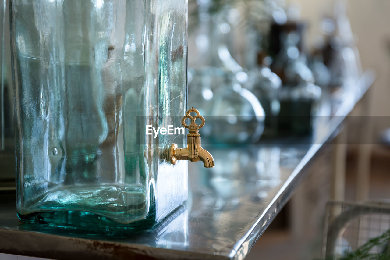 Close-up of faucet in glass container