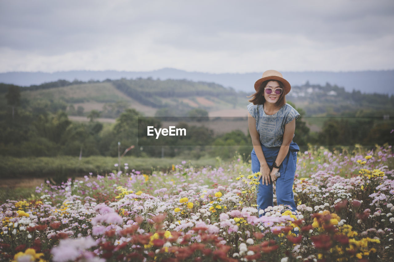 Beautiful woman standing in blooming flower garden