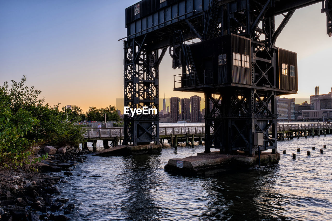 BRIDGE OVER RIVER IN CITY AGAINST SKY