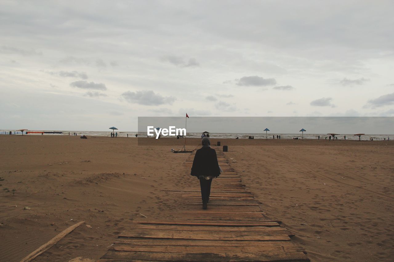 Rear view of woman standing on beach