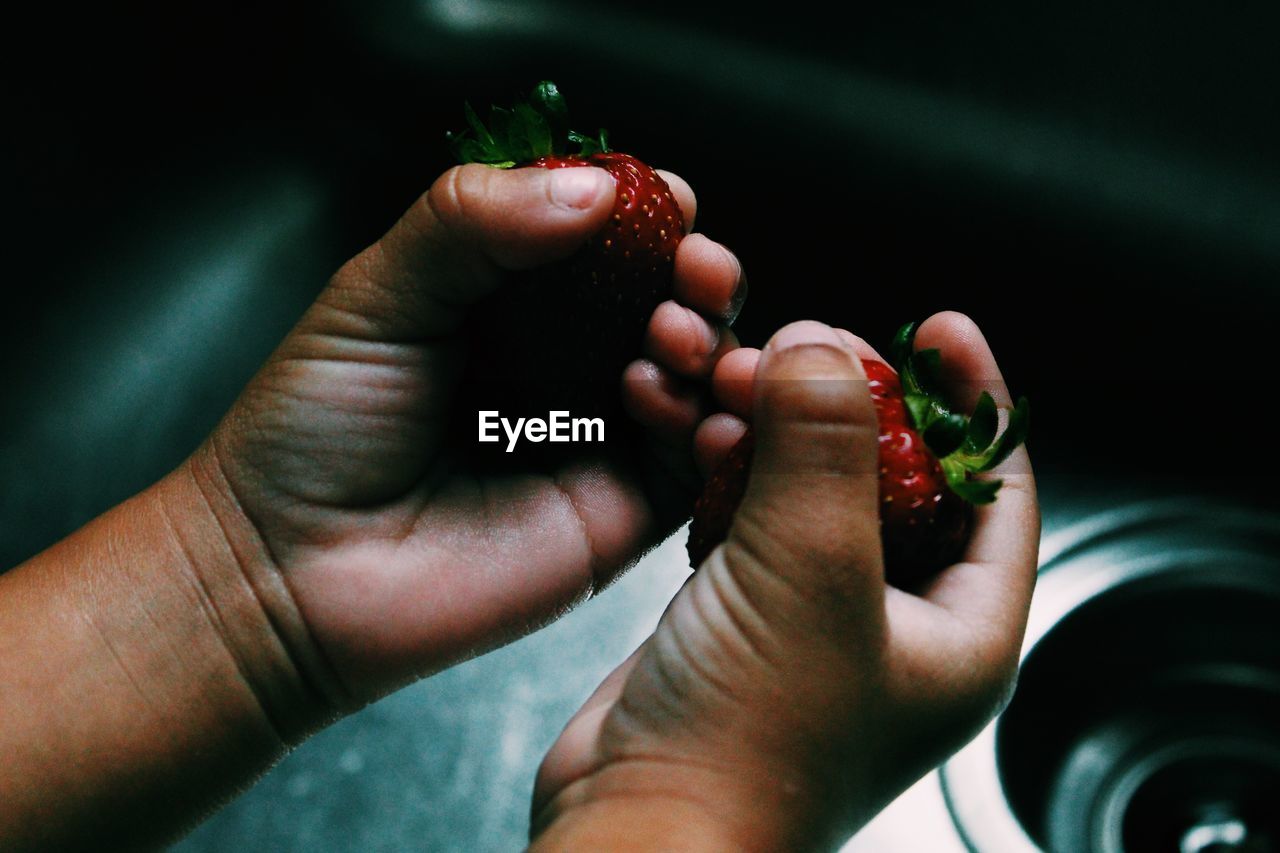 Close-up of person holding strawberries