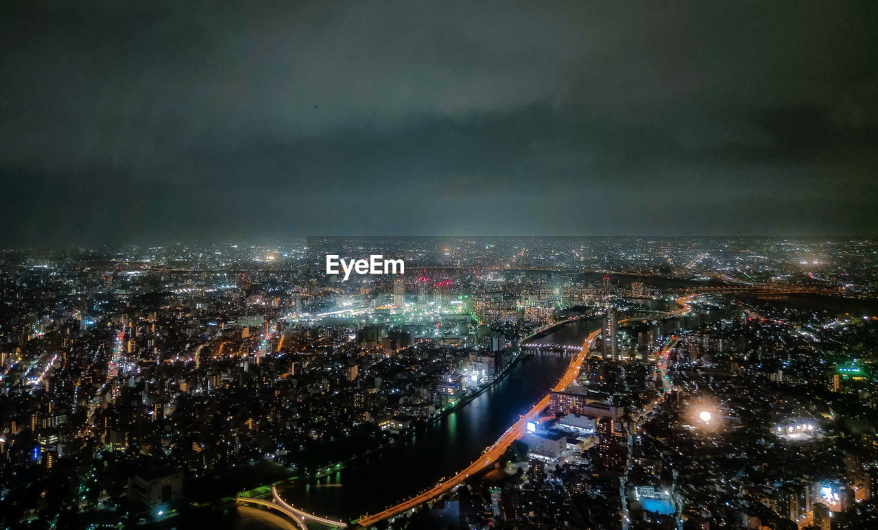 High angle view of illuminated city against sky at night