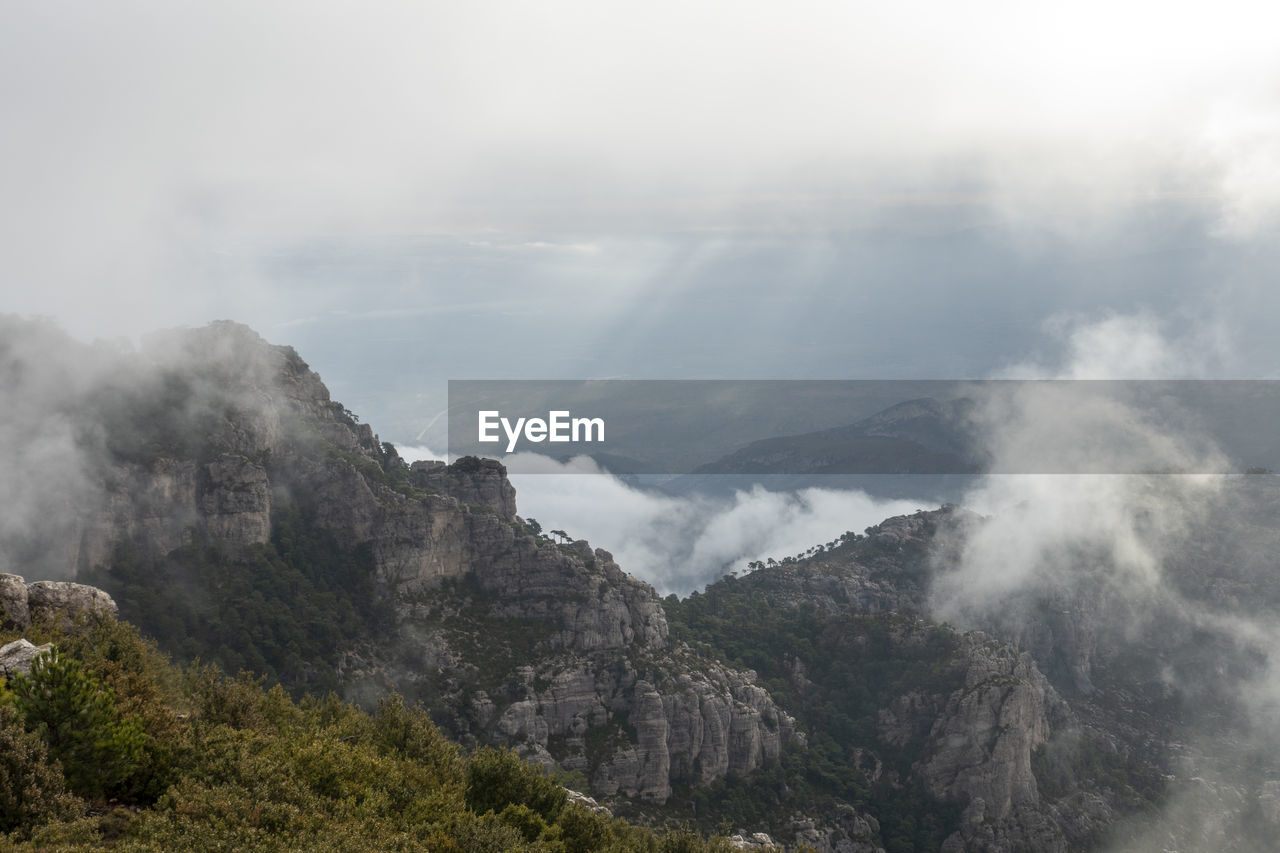 SCENIC VIEW OF MOUNTAINS AGAINST CLOUDY SKY