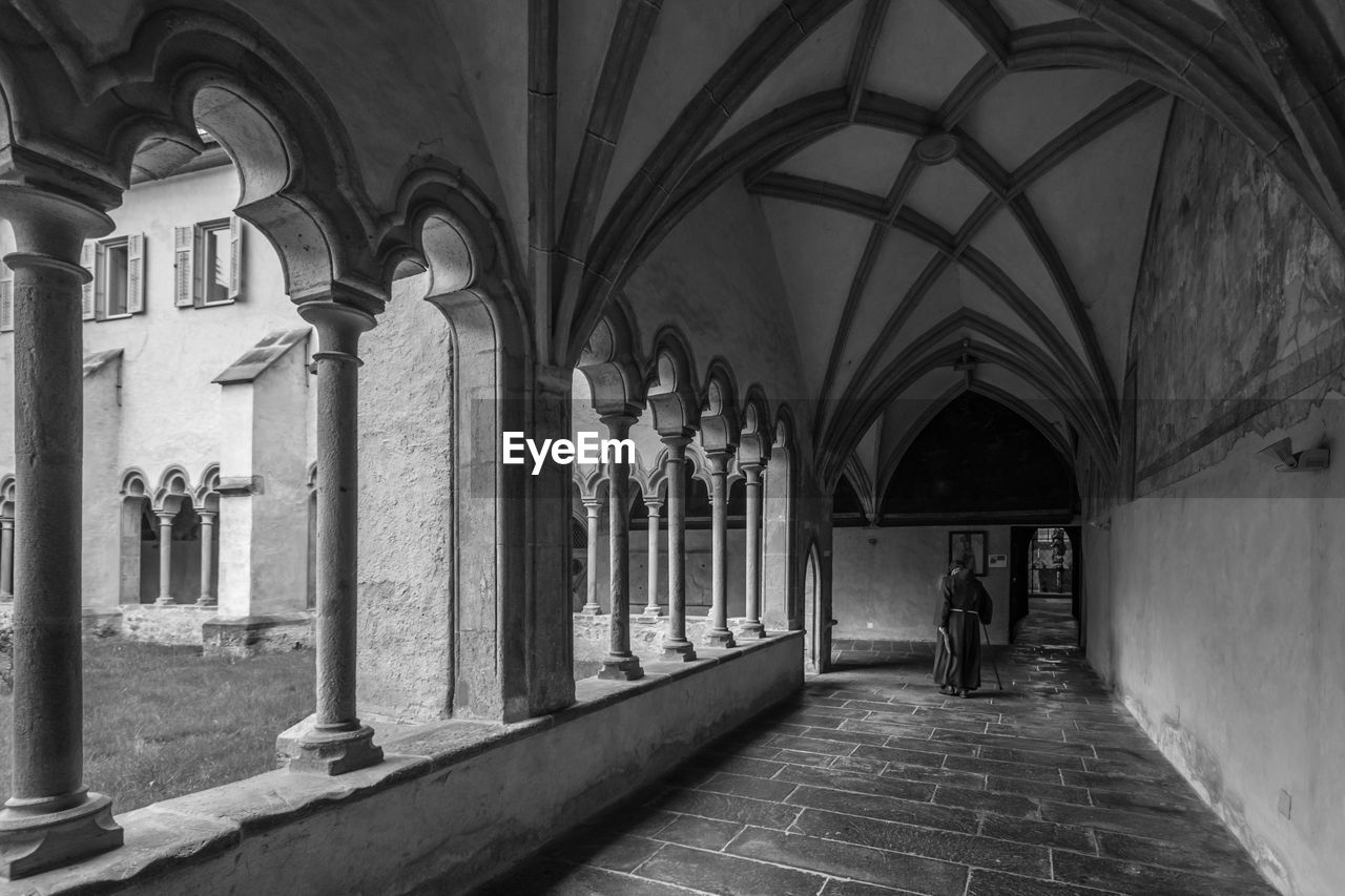 Woman walking in corridor of historic building