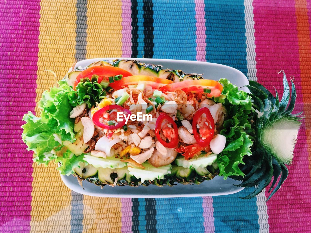 Directly above shot of food served in bowl on colorful tablecloth