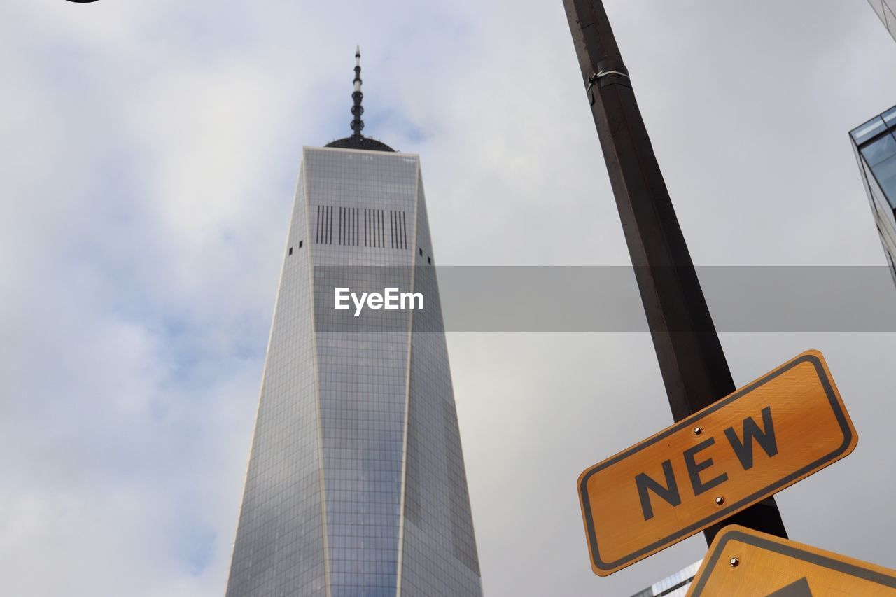 LOW ANGLE VIEW OF ROAD SIGN AGAINST BUILDING