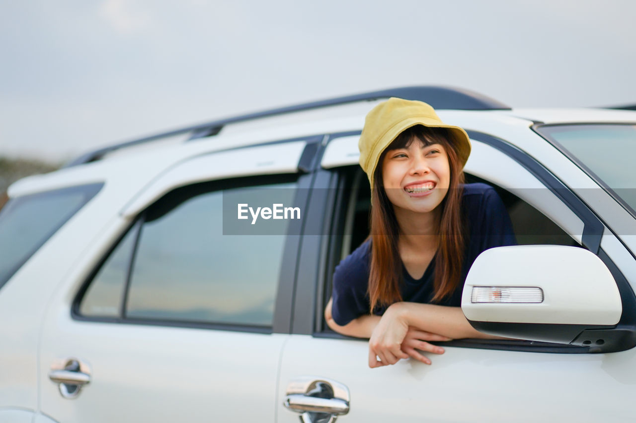 PORTRAIT OF SMILING WOMAN IN CAR