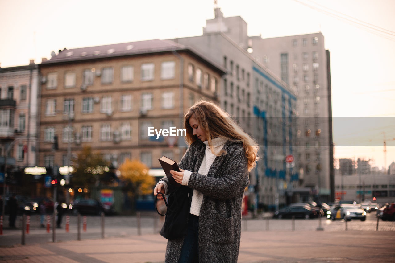 Teenage student girl walking in city during autumn