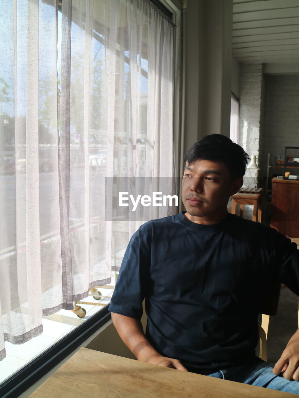 Young man looking through window