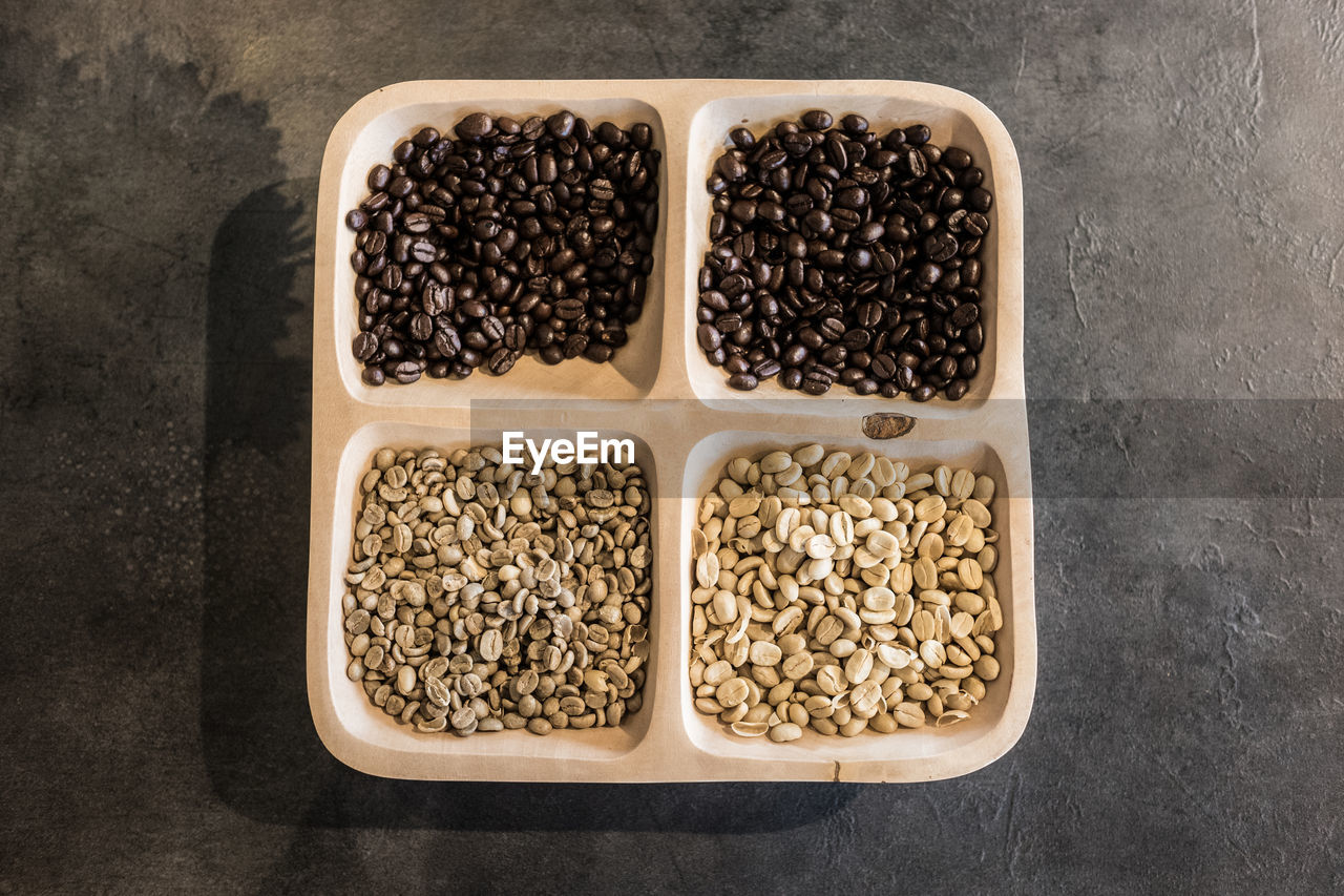 Directly above shot of various coffee beans in container on table