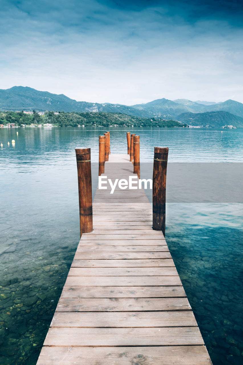 Wooden pier over lake against sky