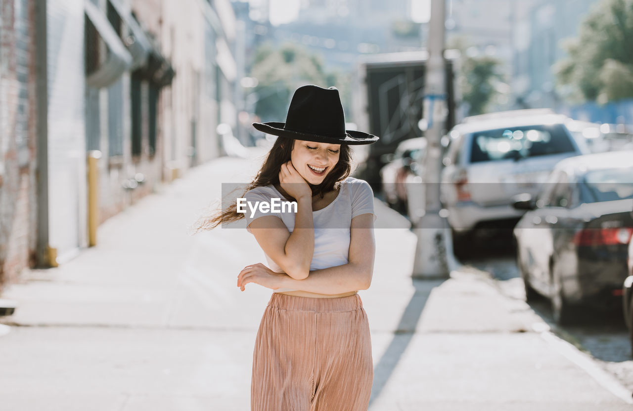 Full length of woman wearing hat standing in city