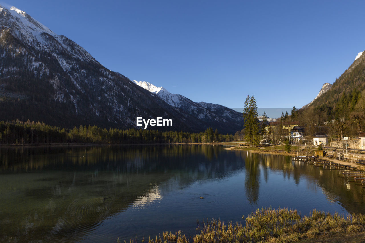 scenic view of lake and mountains against blue sky