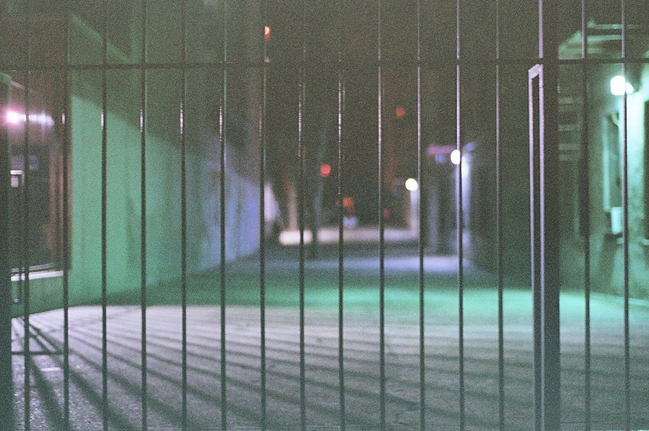 Street seen through fence at night