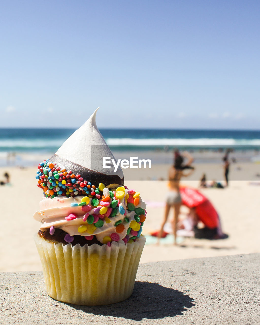 Close-up of cupcakes on beach against sky