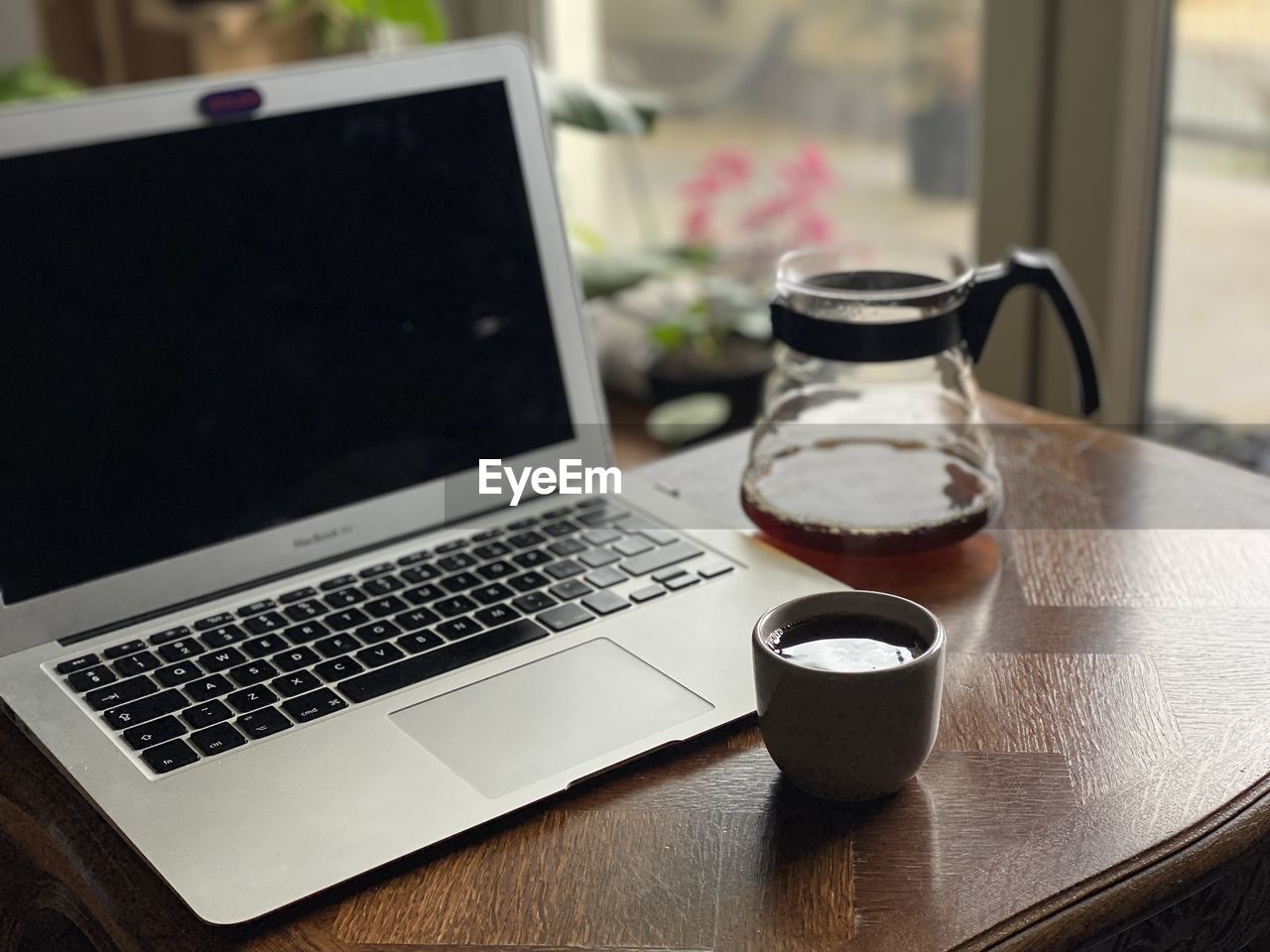 wireless technology, laptop, computer, technology, table, drink, communication, cup, mug, food and drink, coffee, refreshment, indoors, coffee cup, no people, furniture, computer equipment, portable information device, wood, business, still life, day, keyboard, freshness, window, close-up