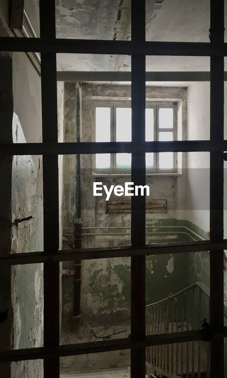 window, architecture, indoors, building, no people, interior design, built structure, abandoned, glass, prison, iron, day, house, punishment, prison cell, wall, light, wood