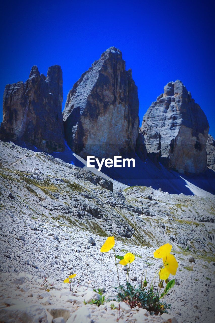 Scenic view of rocky mountains against clear blue sky