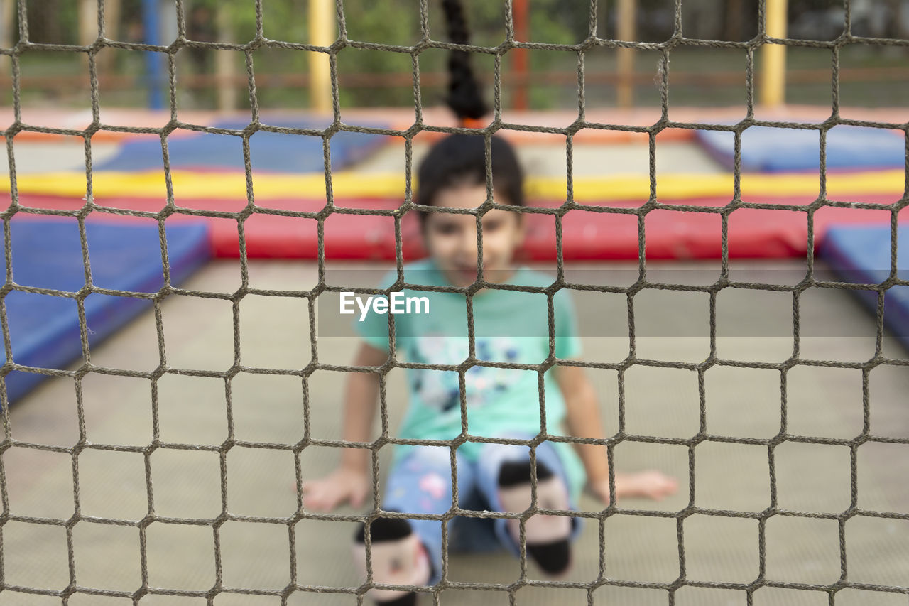 Little girl having fun on trampoline at park outdoors area