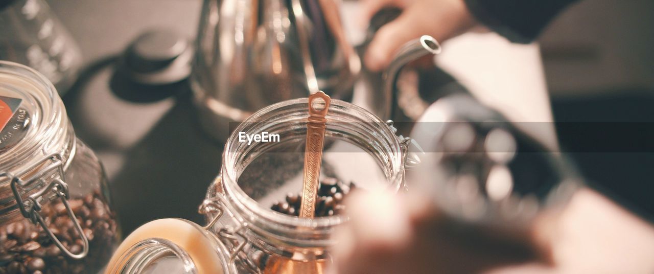 Close-up of spoon in coffee beans on container